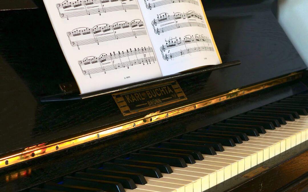 Ein schwarzes Klavier mit Noten – die richtige Musik für ein Video zu wählen ist sehr wichtig